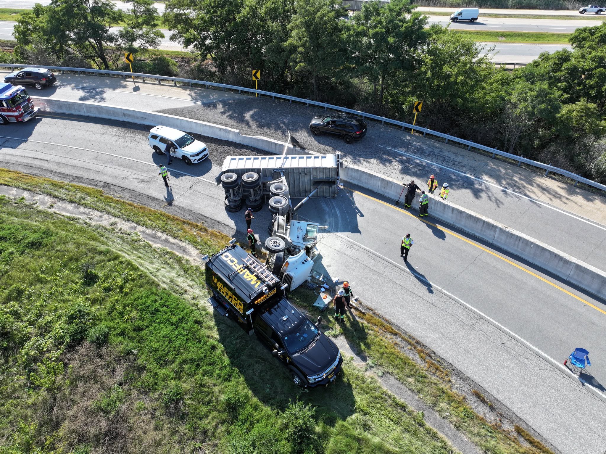 Recovery truck positioned beside an overturned dump truck