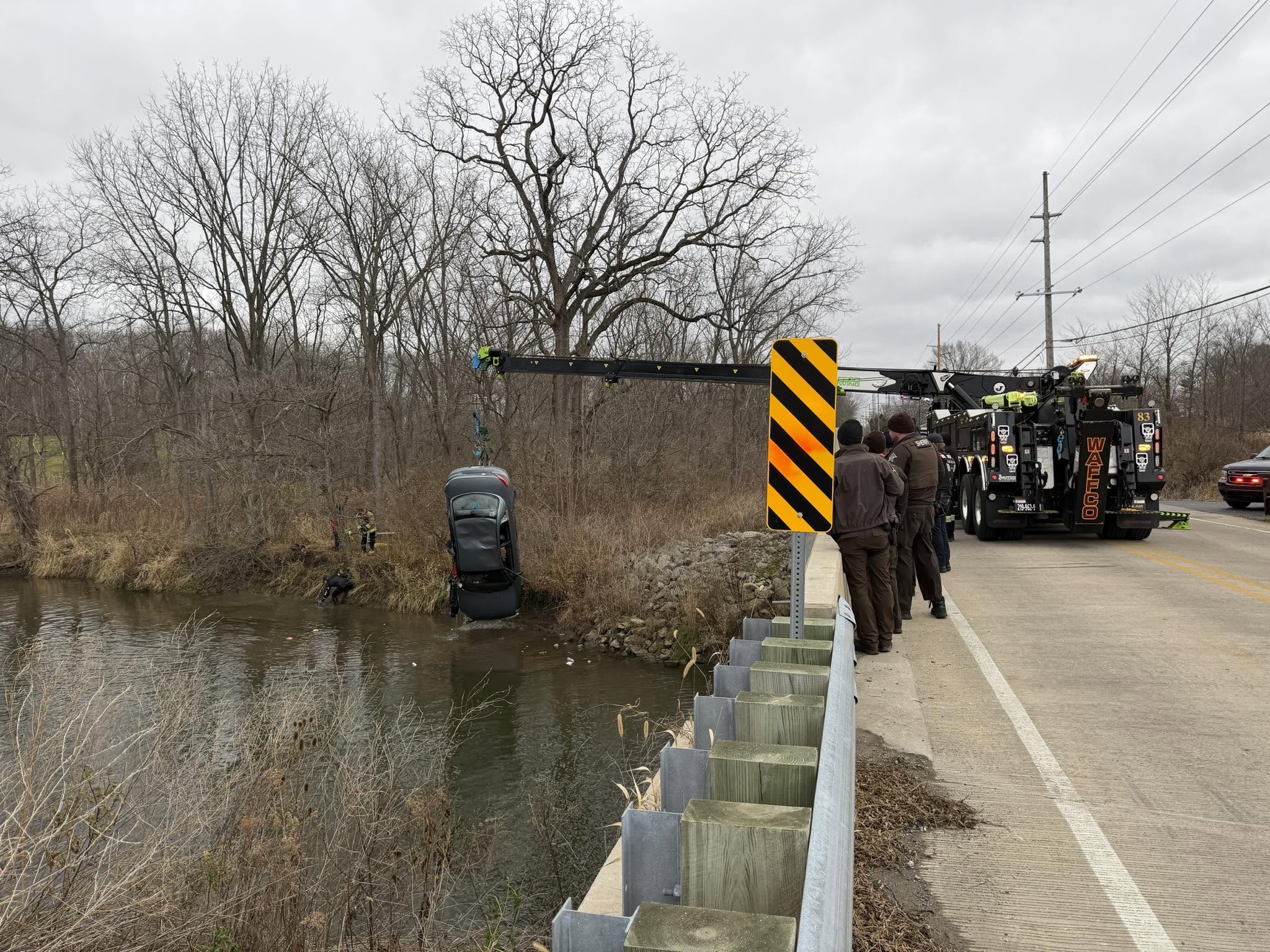 Rotator recovering a vehicle from water near a bridge