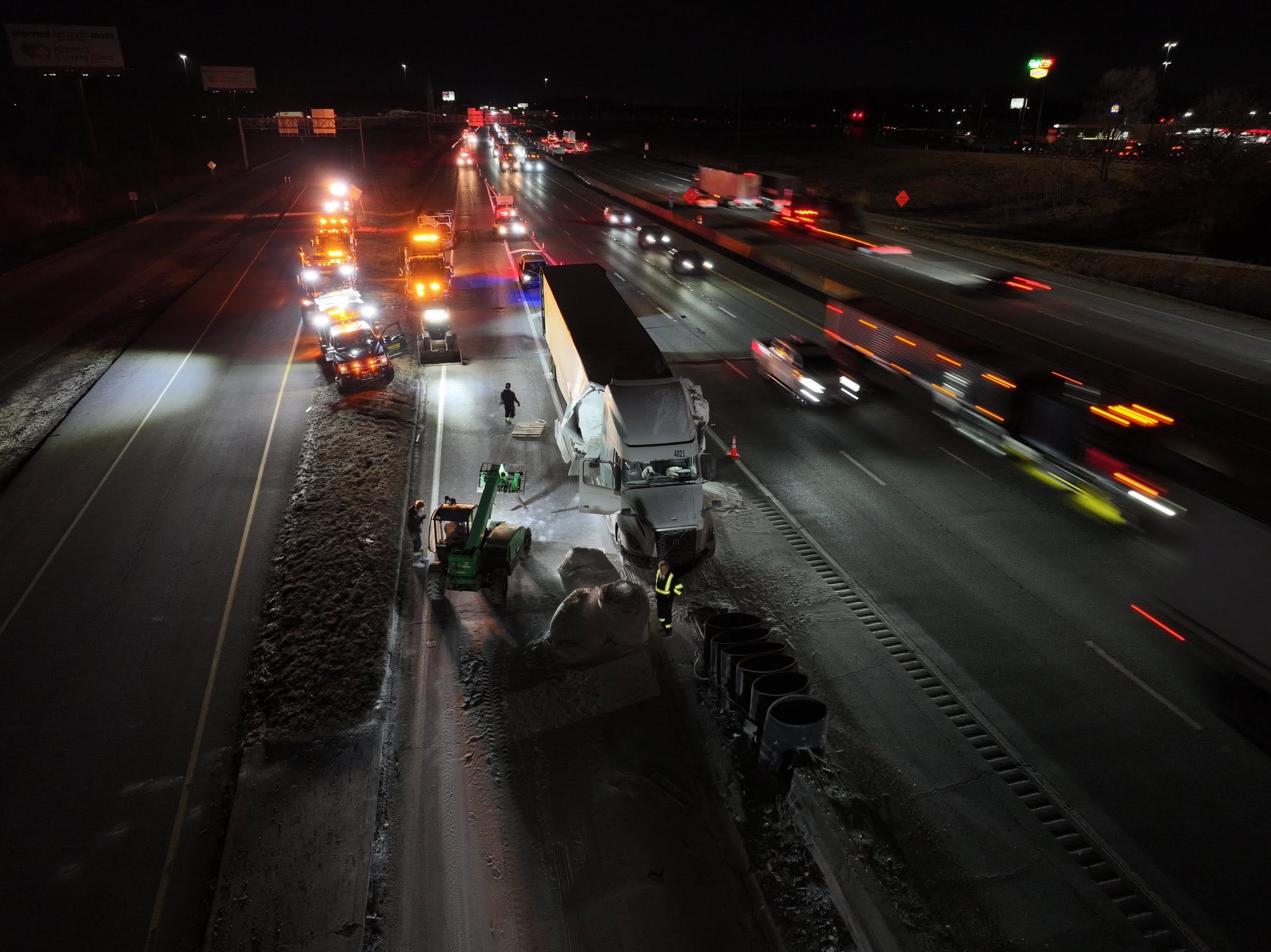 Night freight cleanup on a busy interstate shoulder