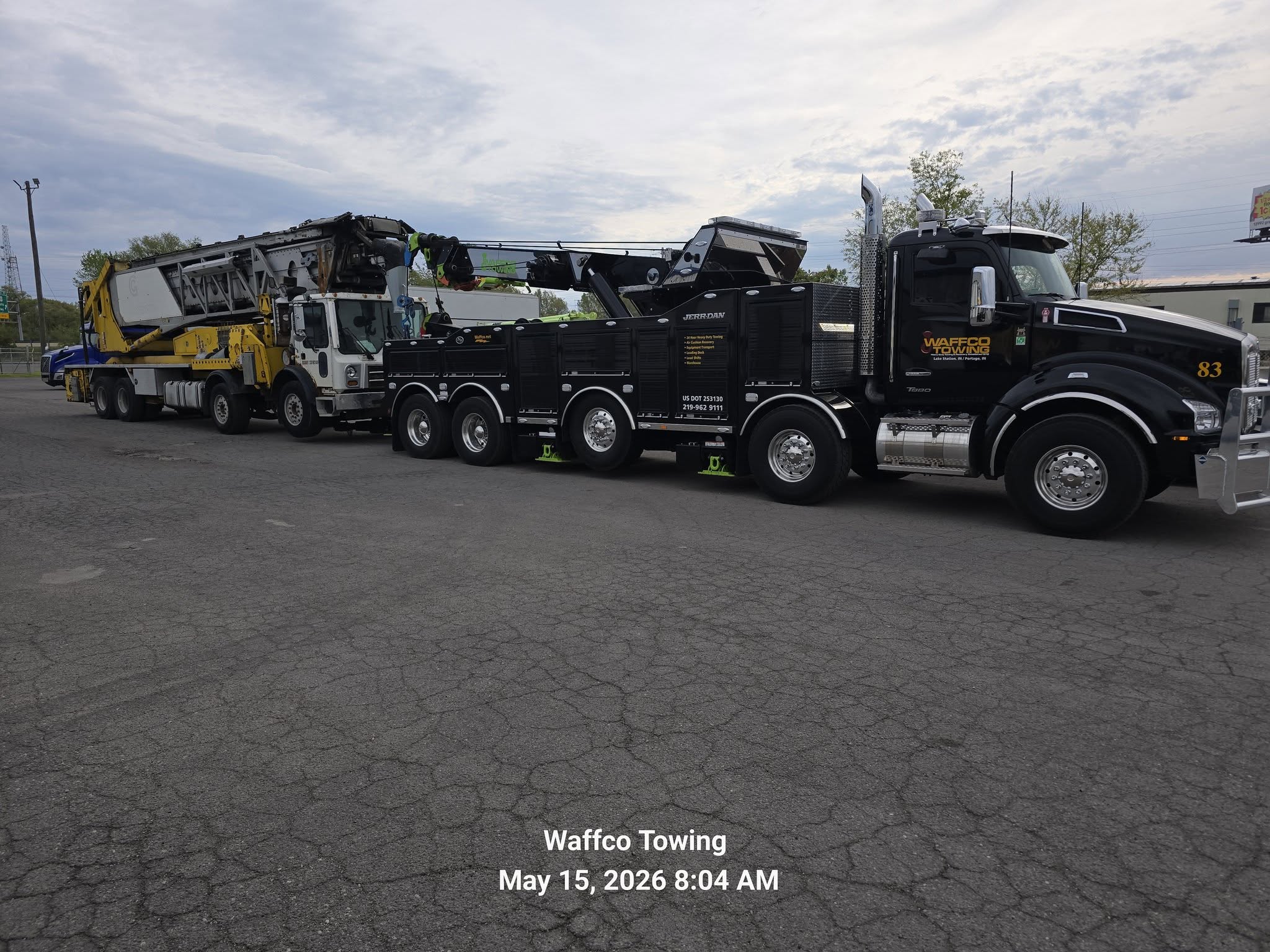 Waffco heavy wrecker towing a large vocational truck